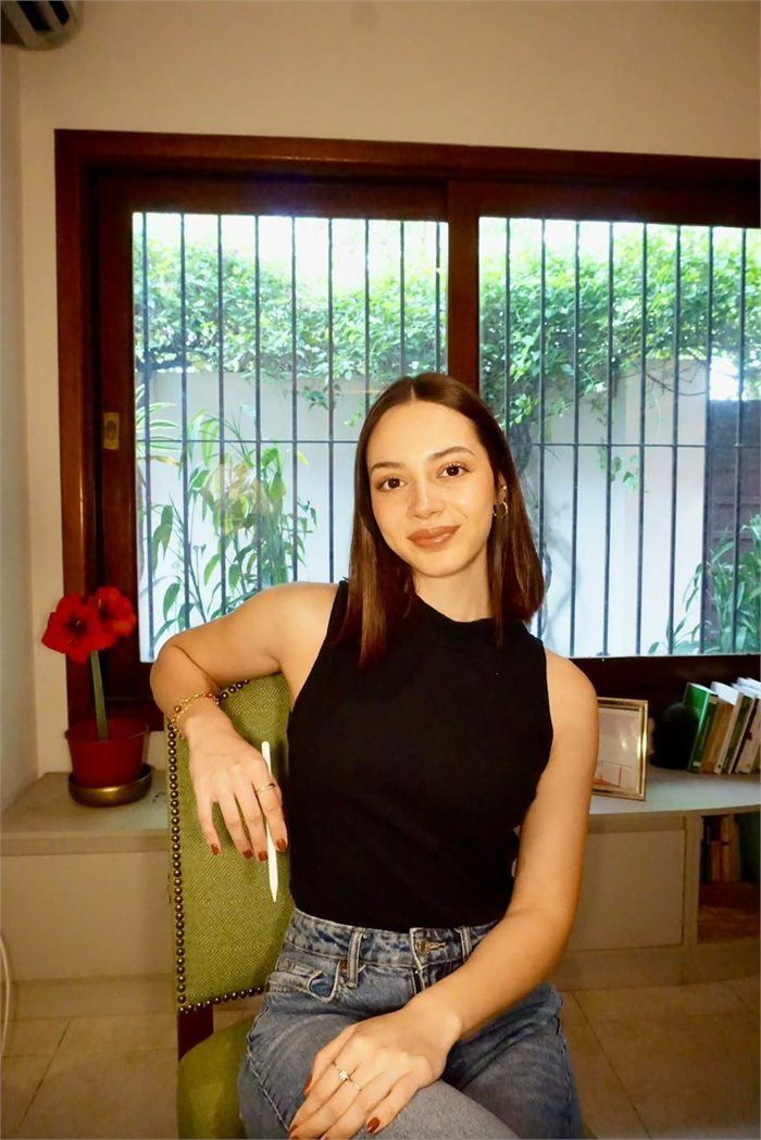 Bianca Báez sentada en su consultorio, sonriendo